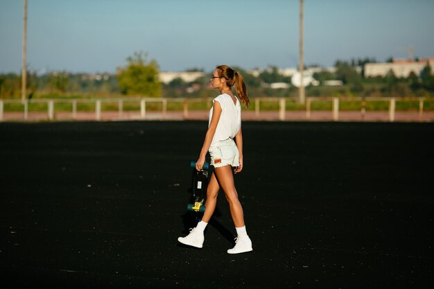 Walking woman view from the side. getting ready for a skateboarding.