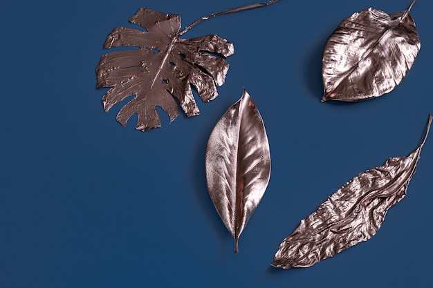 The wall is painted with leaves of gold color on a blue wall .