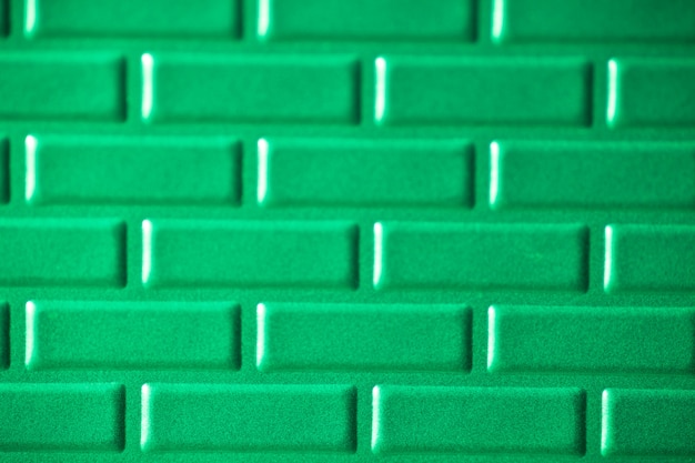 Wall of metallic bricks  green background