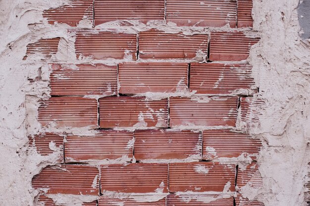 Стена из красного кирпича с белым цементом.