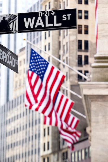 ニューヨーク証券取引所の背景を持つニューヨークのウォール街の看板