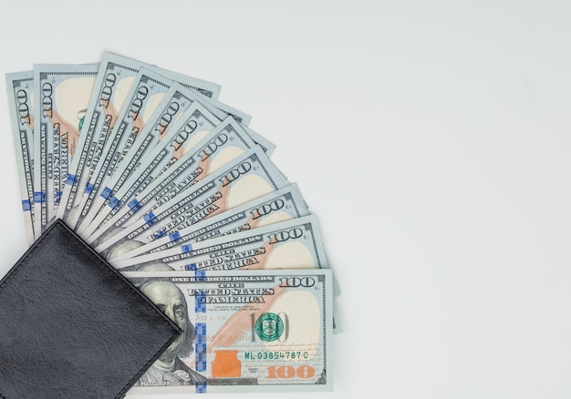  wallet, dollar bills on white table .