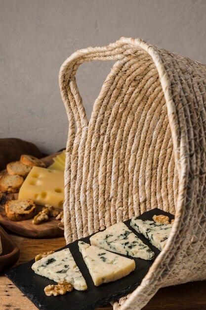 Walnut and blue cheese on black slate in wicker basket