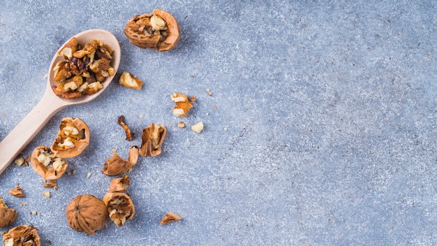 Walnut kernel on wooden spoon over the granite backdrop