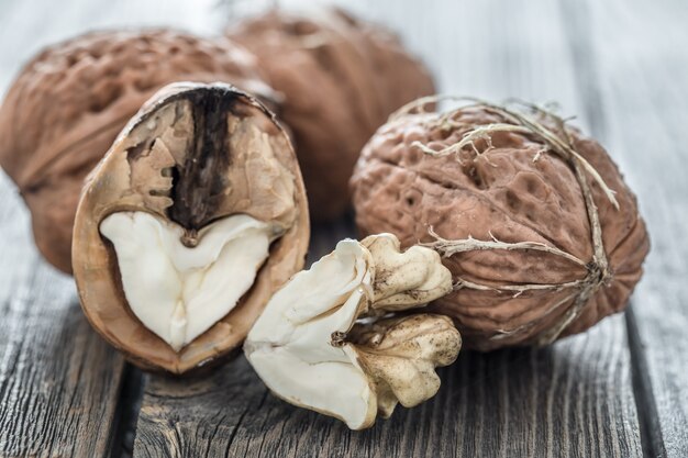 Walnut in open form on a wooden background, close-up .