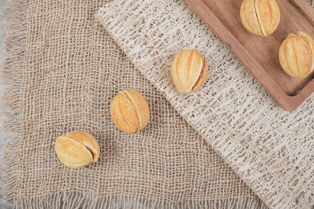 Walnut shaped cookies on burlap and plate.