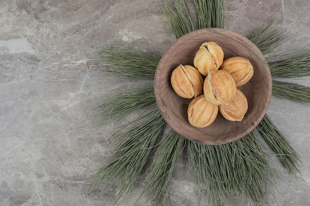 Free photo walnut shaped cookies in wooden bowl.