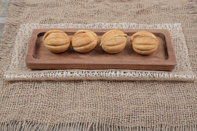 В форме ореха на деревянной тарелке, обтянутой мешковиной.