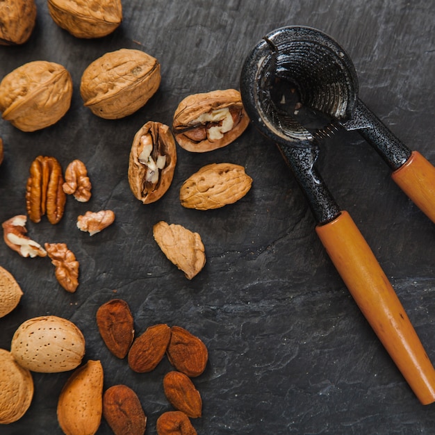 Free photo walnuts, almonds and nutcracker