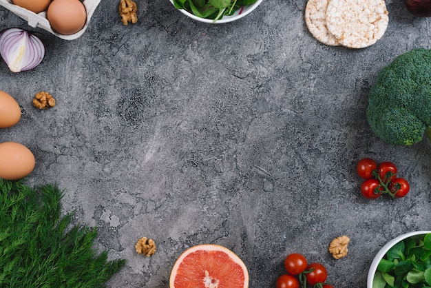 Walnuts and fresh vegetables on concrete gray background