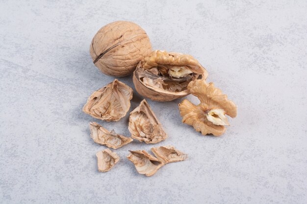 Грецкие орехи и ядра грецких орехов на каменной поверхности. Фото высокого качества