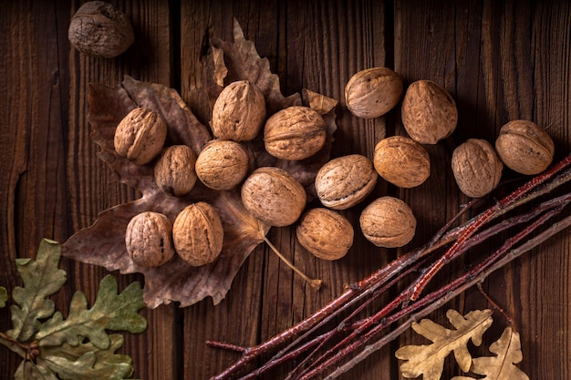 Free photo walnuts on wooden table with leaves