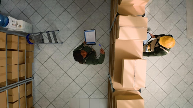 Free photo warehouse coworkers examine parcels