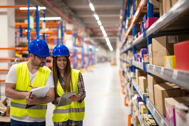 Warehouse employees working together on counting products and checking inventory in storage center