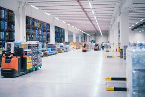 Warehouse industrial building interior with people and forklifts handling goods in storage area
