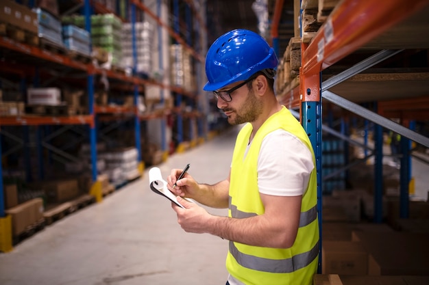 Warehouse worker checking inventory in large distribution center