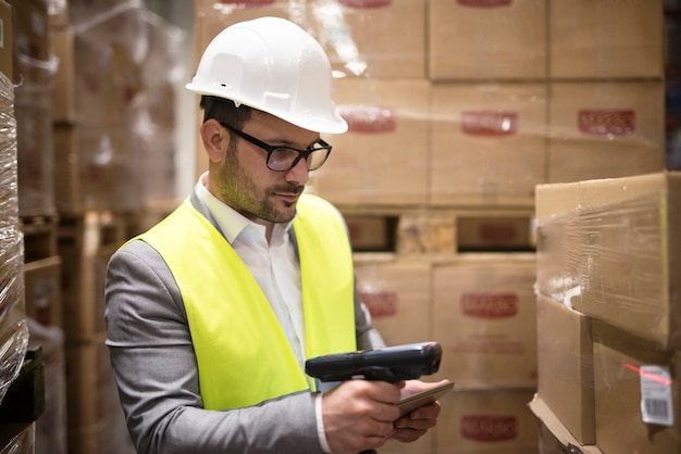 Warehouse worker checking parcels with bar code reader