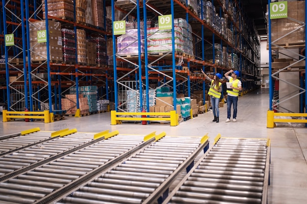 Warehouse workers checking inventory and goods distribution in large storehouse