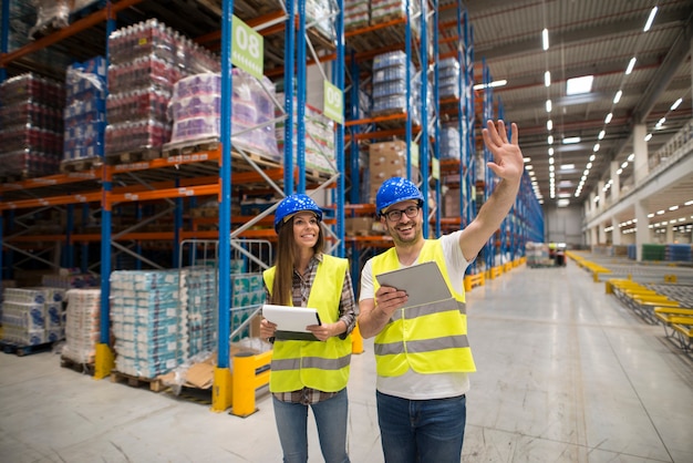 Warehouse workers checking organization and distribution of products in large storage area