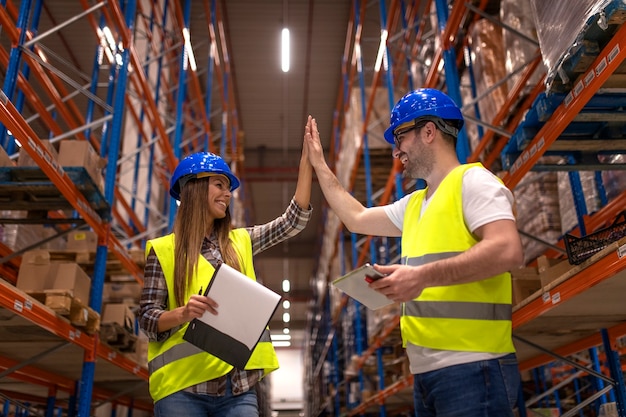 Warehouse workers clapping hands together