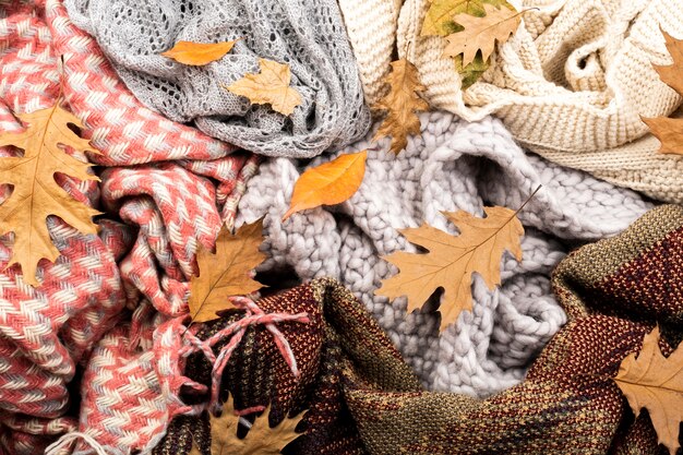 Warm scarves and leaves background 