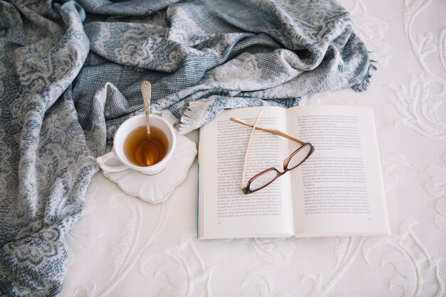 Free photo warm tea and book on bed