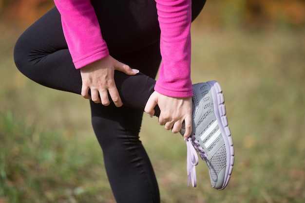 Free photo warming up outdoors in the autumn, holding an ankle