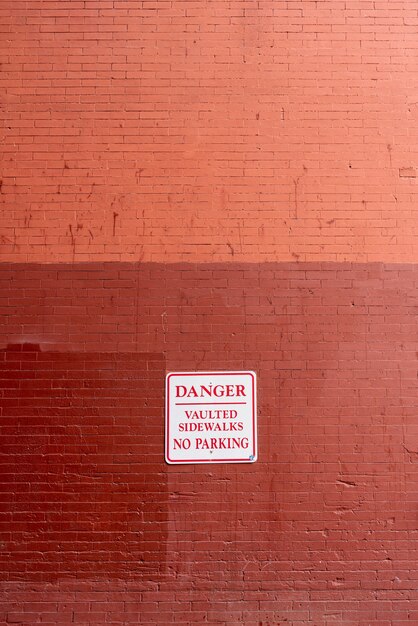 Warning sign on brick wall front view