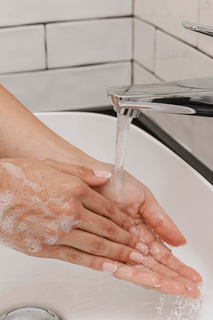 Washing hands rubbing with soap and running water