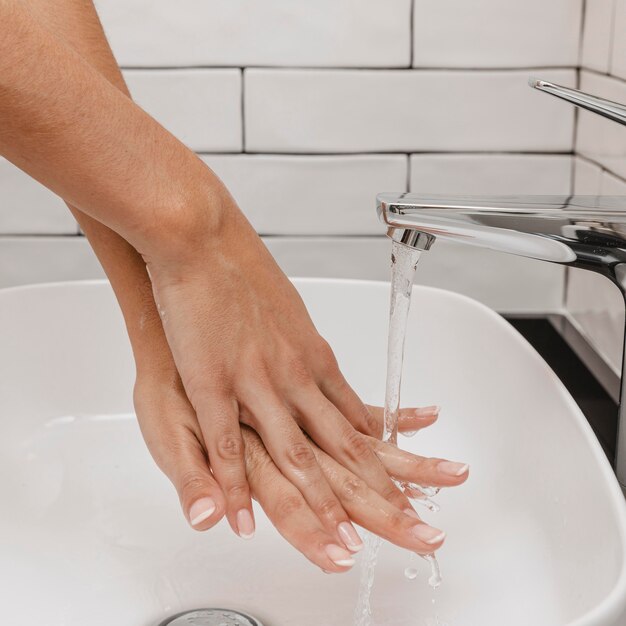 Washing hands rubbing with soap and tap water