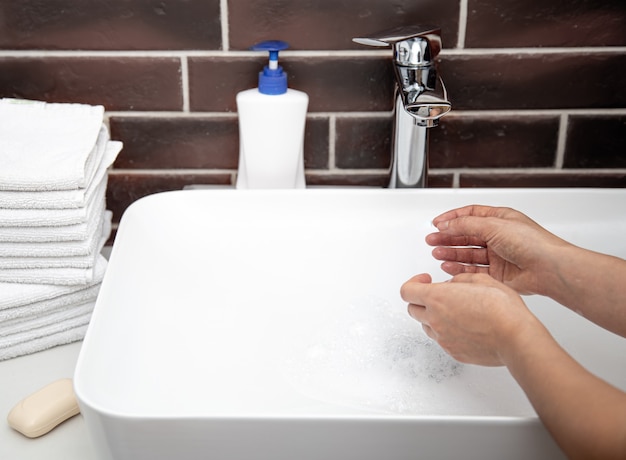 Foto gratuita lavarsi le mani con acqua corrente in bagno. il concetto di igiene personale e salute.