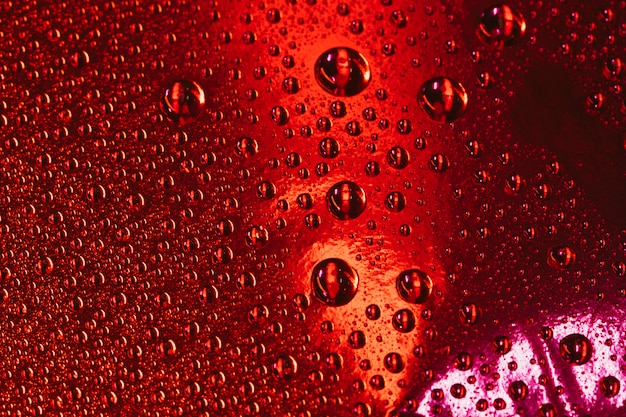 赤いテクスチャ背景の上の水の気泡
