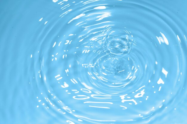 Water drop on clean blue water background