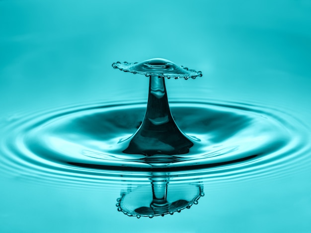 Столкновение капли воды с абстрактным синим эффектом