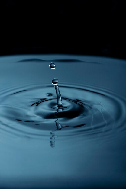 Water droplets creating ripple in liquid