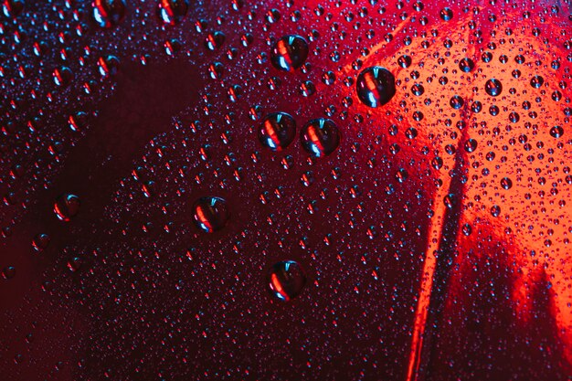 Water droplets on the red reflective glass