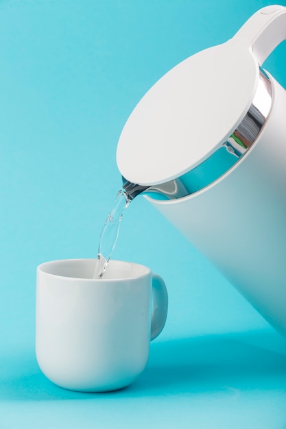 Free photo water electric kettle and white cup
