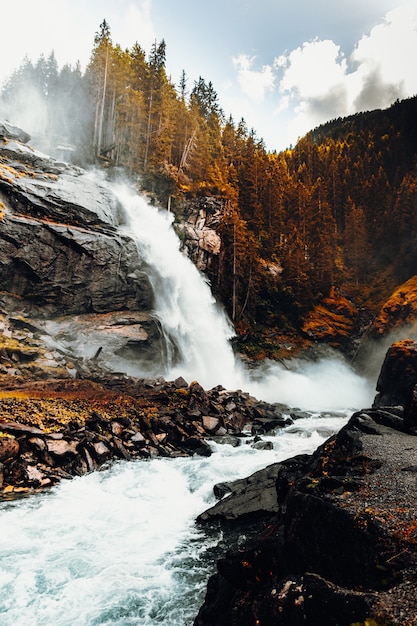 Water falls on brown rocky mountain during daytime