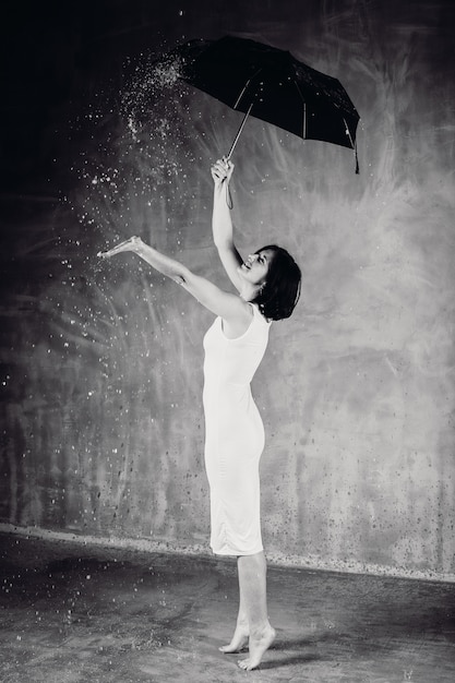 Water falls over woman under black umbrella