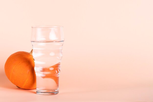 Water glass and pumpkin with copy-space