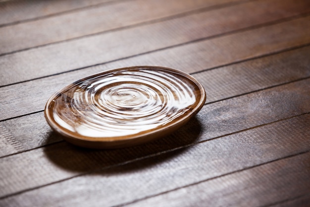 Free photo water ripples in a wooden bowl