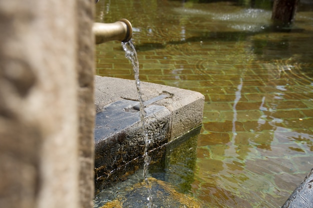 Вода работает в старый фонтан из