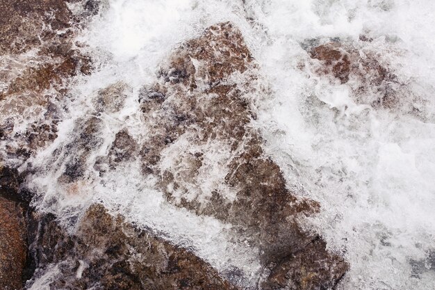 Water splashes against the rocks on the river 