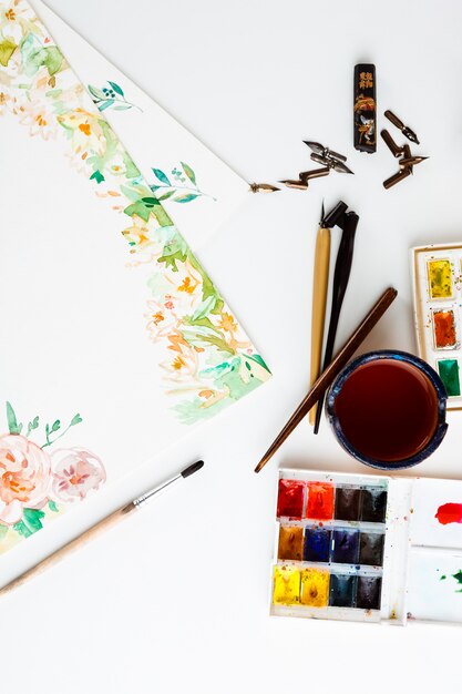 watercolor paints brushes art details over white wall