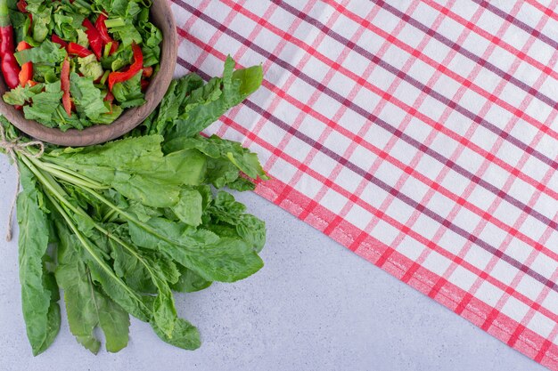 Watercress leaves and a bowl of salad on marble background. High quality photo