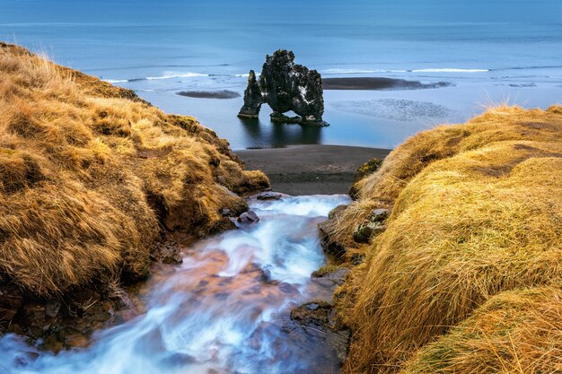 폭포와 Hvitserkur는 아이슬란드 북부 해안의 바다에있는 멋진 바위입니다.