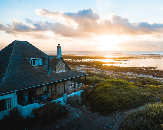 Waterfront house on the beach with a beautiful setting sun in the horizon