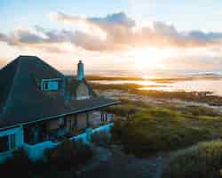 무료 사진 수평선에 아름다운 석양과 해변에 워터 프론트 하우스