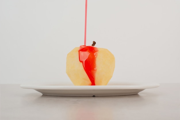Foto gratuita innaffiare una mela con piatto bianco om sciroppo.