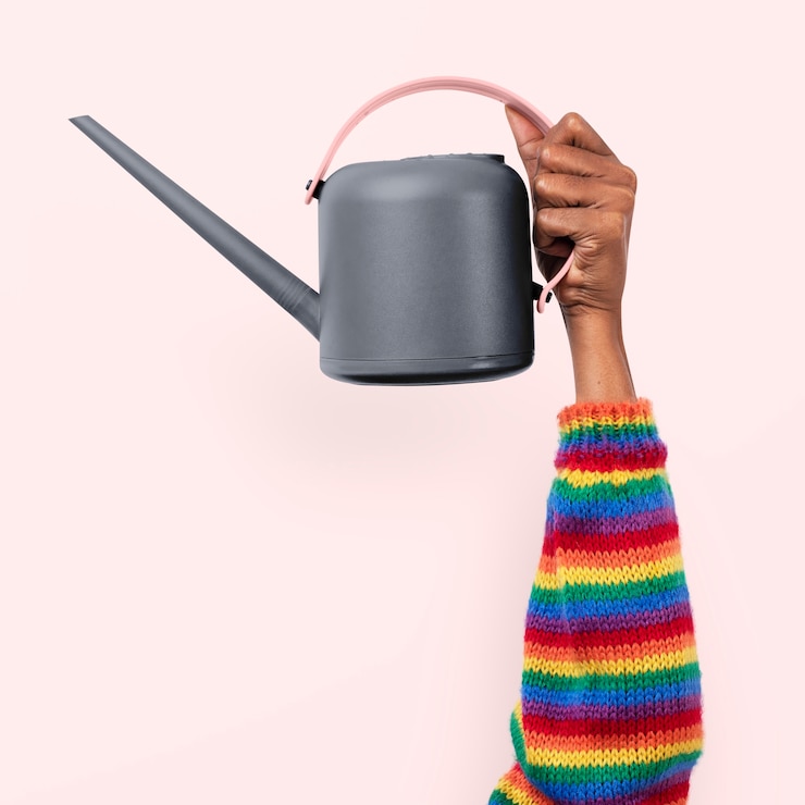 Free Photo watering can gardening tool held by a person with rainbow sleeves